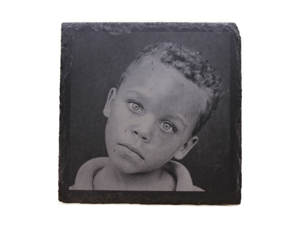 Lasergravur eines Kinderporträts auf Schieferplatte, detailreich und kontraststark ausgeführt.