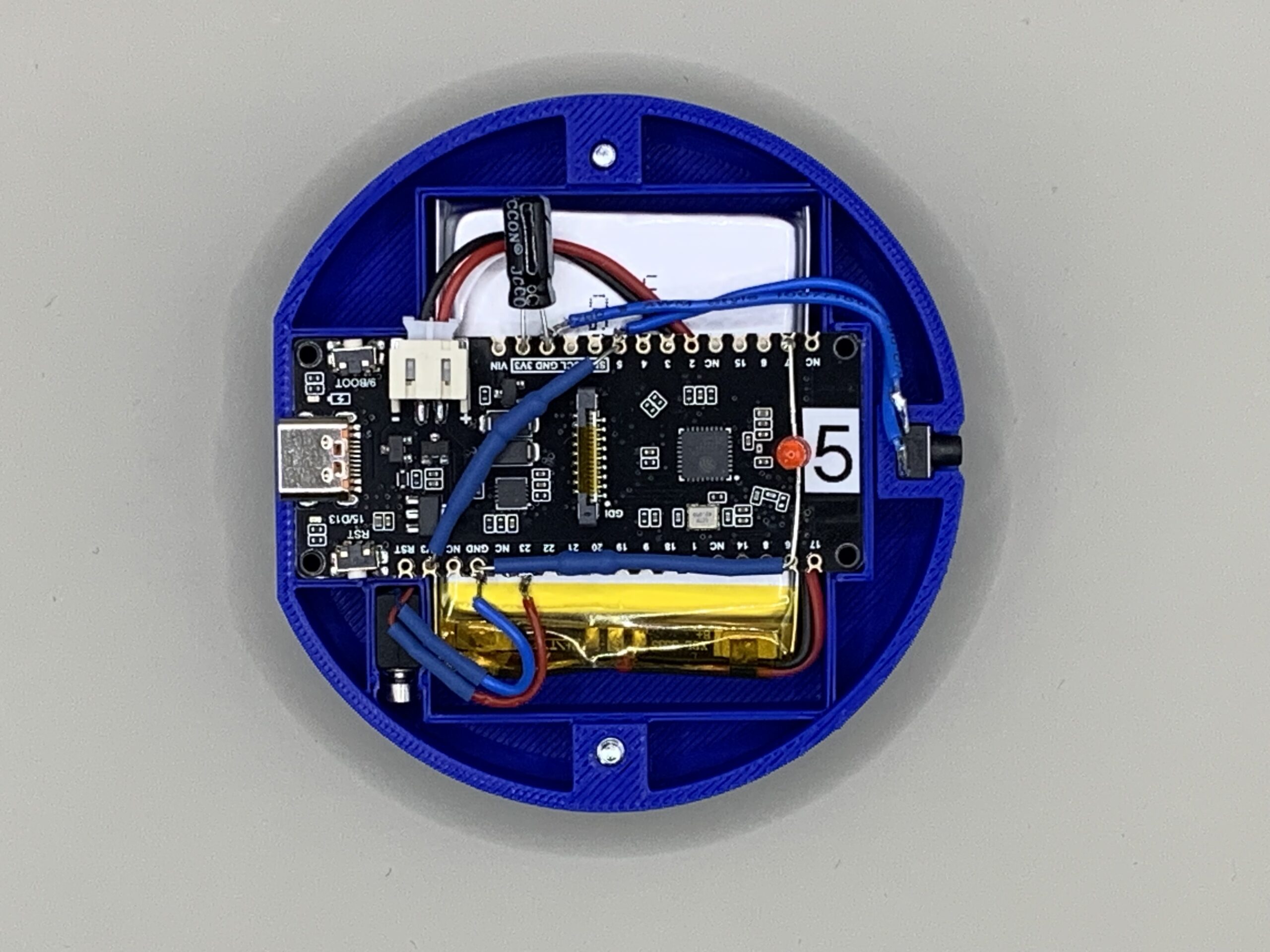 Offenes Service Pager Tischgerät mit ESP32-C6, Akku und Vibrationsmotor im blauen 3D-gedruckten Gehäuse.